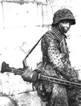 Soldat german purtând o mitralieră MG-42, pe frontul din Franța, în 1944 (© Das Bundesarchiv Bild 146-1983-109-14A)