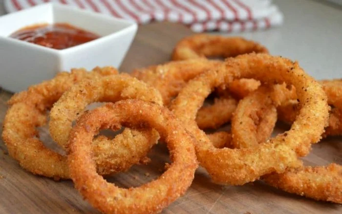 Un aperitiv delicios, ușor de făcut și ieftin: inele de ceapă în crustă de pesmet şi parmezan. Arată foarte frumos și este și gustosFOTO: adevarul.ro