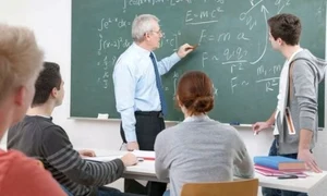 profesor dascal scrie cu creta pe tabla elev scos la tabla elevi in banci la scoala in clasa matematica jpeg