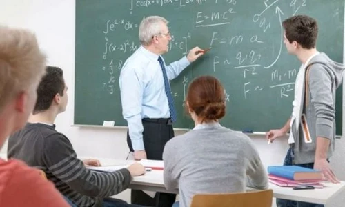 profesor dascal scrie cu creta pe tabla elev scos la tabla elevi in banci la scoala in clasa matematica jpeg