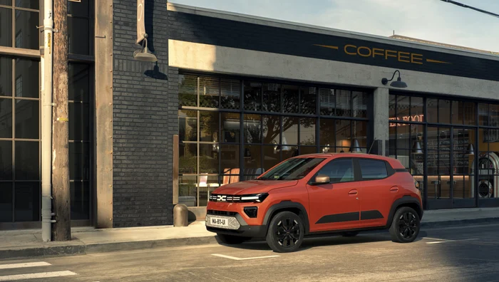 Dacia Spring parcată în fața unei cafenele
