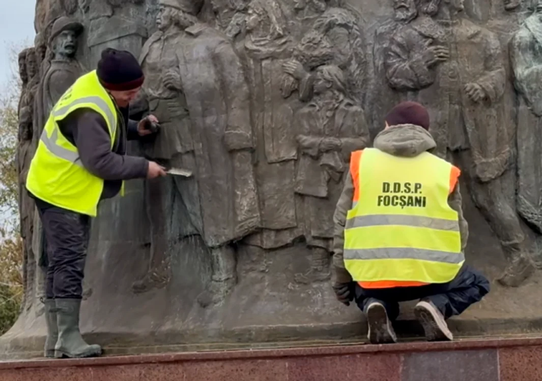 Cei doi muncitori șefuind monumentul Unirii cu perii de sârmă FOTO: Captură video