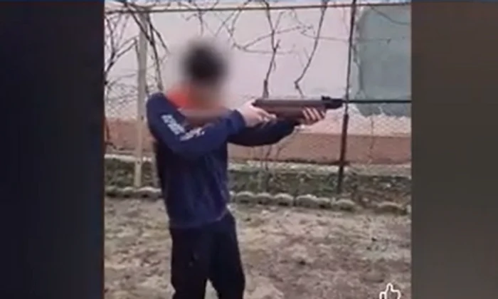 Fiul minor a fost încurajat să tragă cu arma. FOTO captură video Antena3 CNN