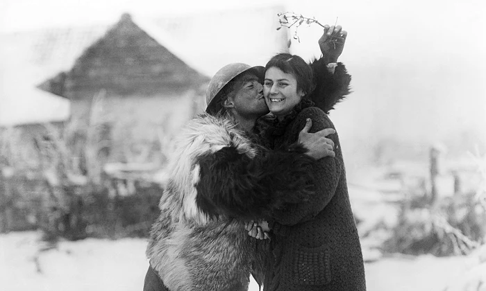 Un soldat britanic sărută o tânără franțuzoaică sub o crenguță de vâsc, în timpul Primului Război Mondial (© Imperial War Museum)