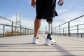 back view man with mechanical leg sunny day sportsman black shorts white sneakers photographed training sport disability hobby concept jpg