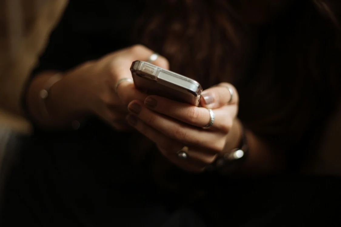 O femeie se uită la un iPhone