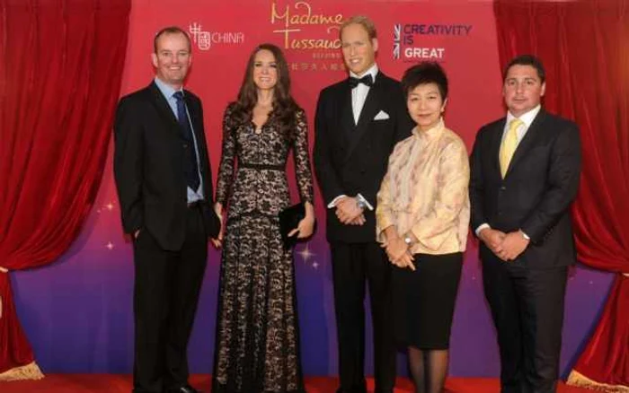 Vizitatori din Beijing, lângă copia de ceară a Ducesei de Cambridge şi a prinţului William