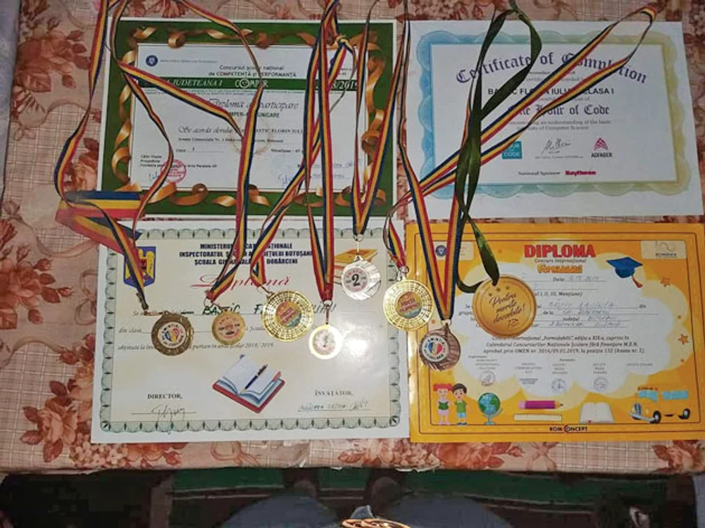 Diplomele şi medaliile  de care băieţelul  e tare mândru 