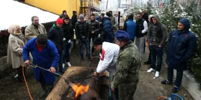 Laurenţiu Reghecampf (cu căciulă roşie) şi jucătorii au asistat la sacrificarea porcului FOTO: CLICK!