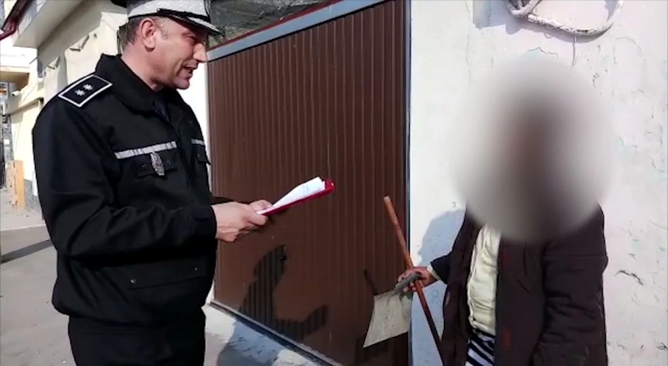 Poliţistul local îi explică unui părinte ce sancţiuni riscă dacă copilul nu va frecventa cursurile şcolare Foto: captură video
