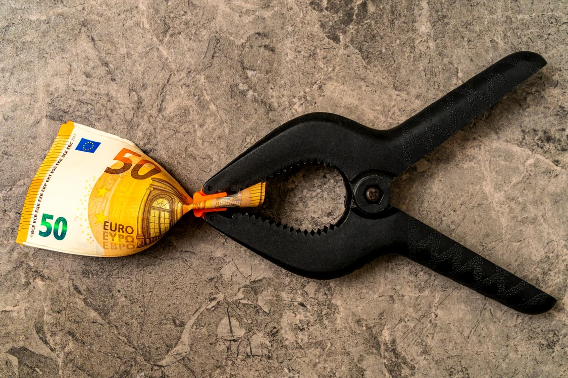 50 de euro strânși cun un clește negru, sugerând devalorizare