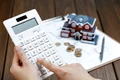 female hand operating calculator front villa house model 1 scaled jpg