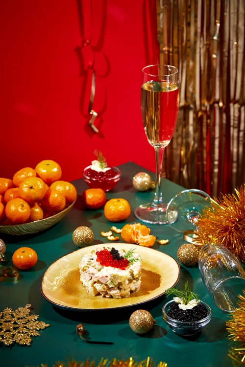 Salată boeuf festivă, pe o masă cu decorațiuni de sărbători și mndarine