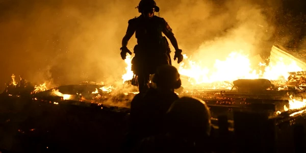 Soldaţi separatişti trec pe lângă o clădire în flăcări în Doneţk