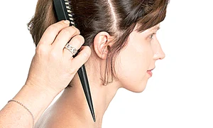 Separă partea superioară  de restul părului şi  prinde o într o coadă în  vârful capului cu un  elastic, lăsând bretonul  să cadă lejer pe frunte  jpeg