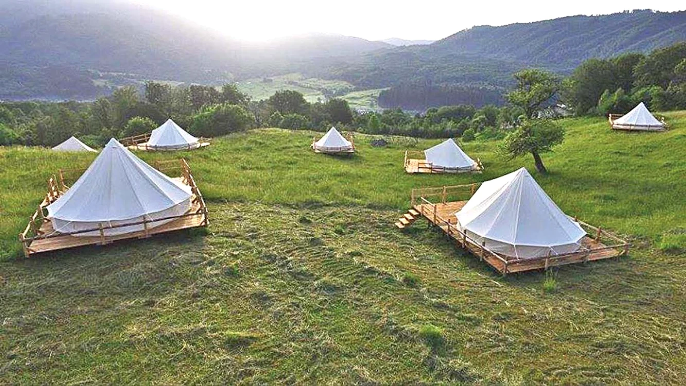 
    Corturile sunt instalate la baza muntelui, într-un cadru de vis  