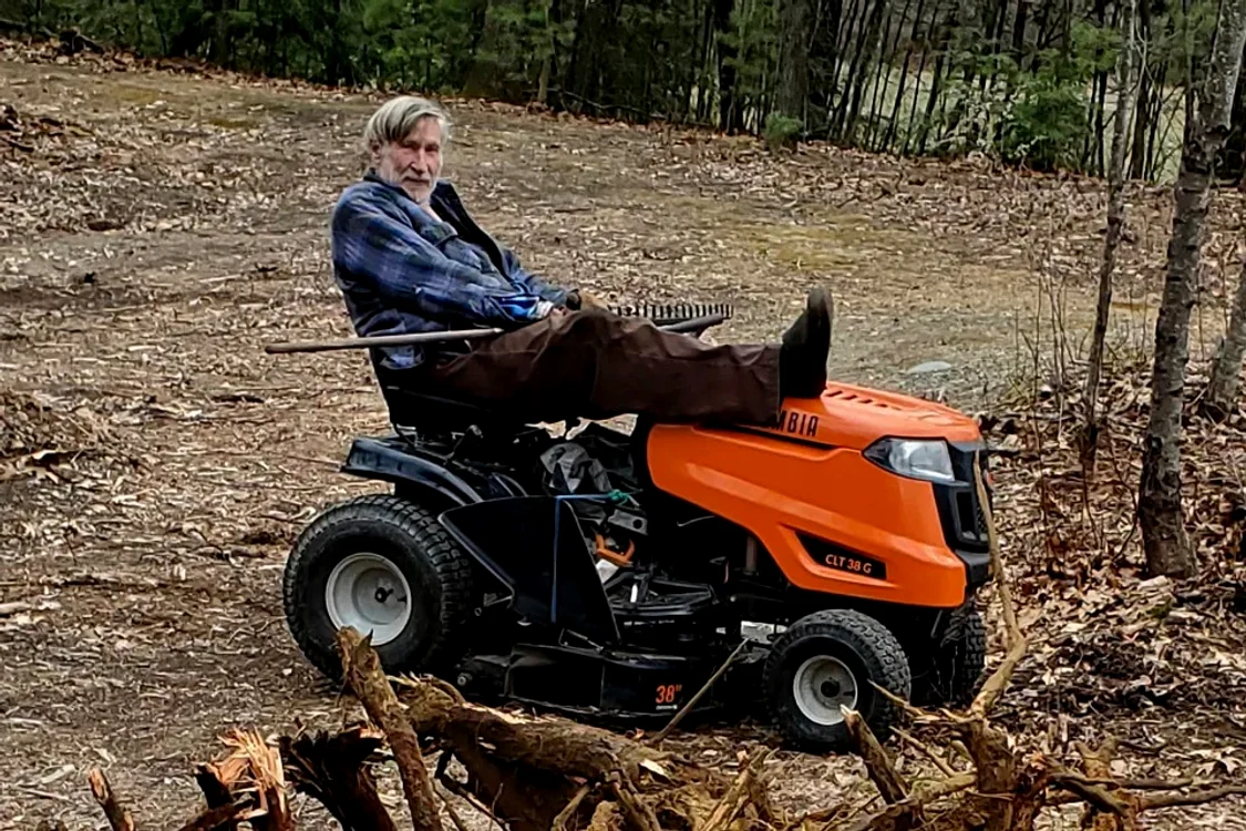 Milionarul Goeffrey Holt într-un parc, alături de mașina de tuns iarba
