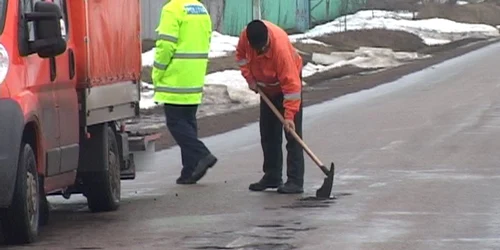 Muncitorii acoperă gropile cu pământ FOTO