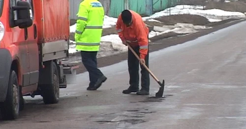 Muncitorii acoperă gropile cu pământ FOTO