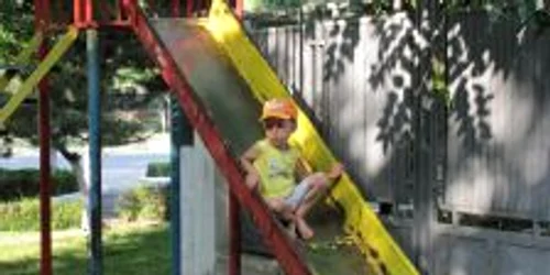 Copiii îşi rup hăinuţele pe topoganele ruginite