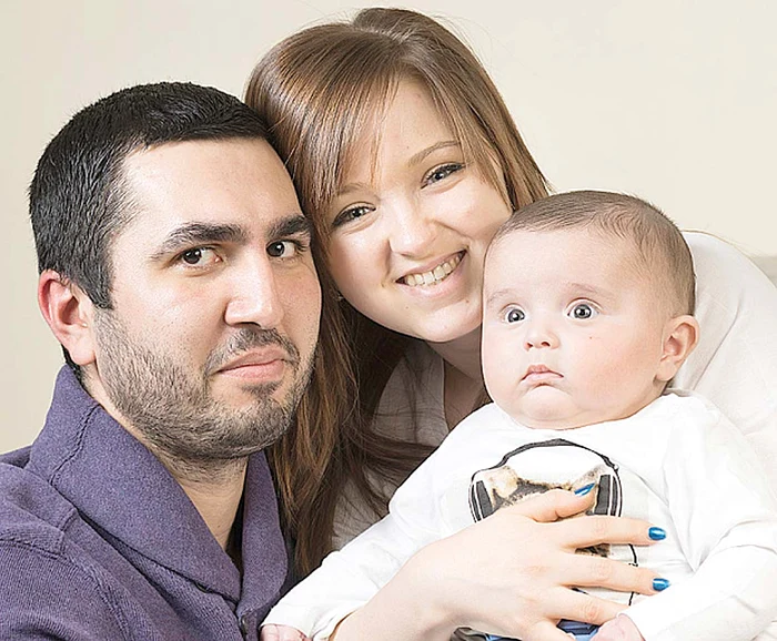 Micuţul Lucas, fericit în braţele părinţilor săi, Carmen şi Gabriel Neagu