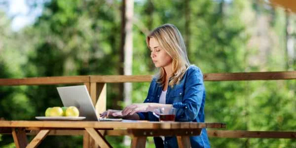 laptop femeie sat decor rural gradina terasa telemunca foto shutterstock