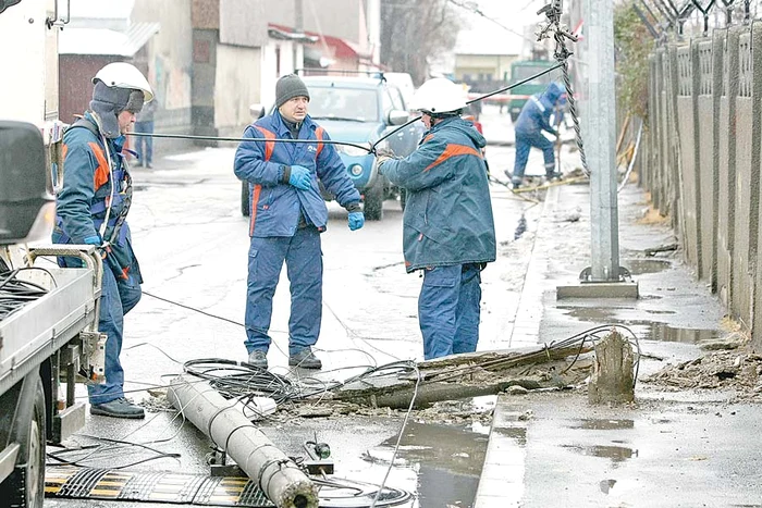 Salariaţii ENEL s-au chinuit ore întregi să înlocuiască stâlpii prăbuşiţi