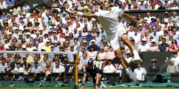 Roger Federer loveşte o minge în timpul finalei de tenis contra lui Novak Djokovic la Campionatul de tenis de la Wimbledon Londra FOTO Reuters