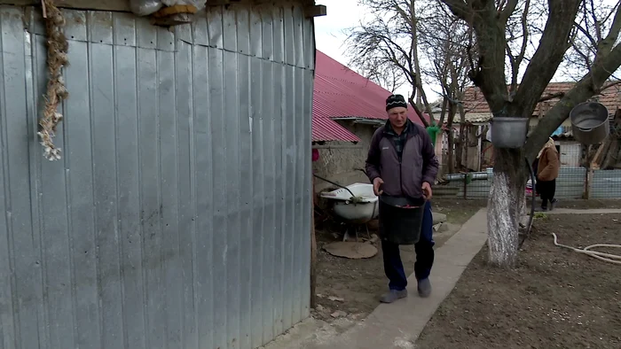 Gospodarul strecoară coceni în sobe, ca să economisească lemnul. FOTO I. Bunilă