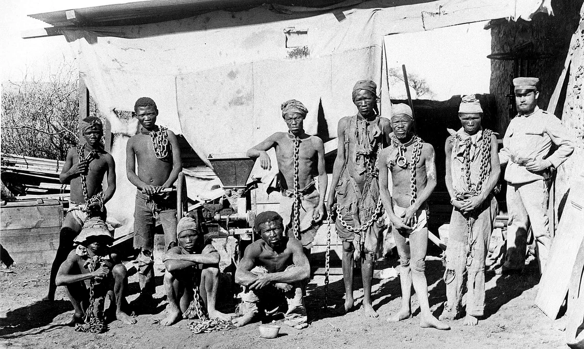 Etnici Ovaherero și Nama, în lanțuri, în timpul genocidului din Namibia (© Wikimedia Commons)
