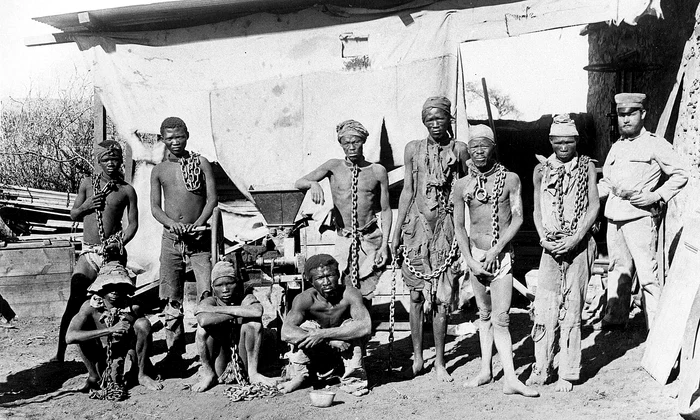 Etnici Ovaherero și Nama, în lanțuri, în timpul genocidului din Namibia (© Wikimedia Commons)