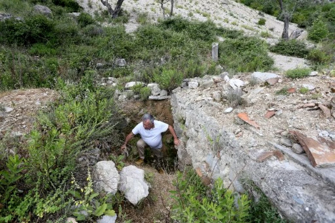 Arheologul Skender Mucaj inspectează gropi săpate de vânătorii ilegali de comori la ruinele Bisericii Sf. Mara în Brrar, lângă oraşul Tirana, pe 13 iunie 2022.Foto Gent SHKULLAKU / AFP