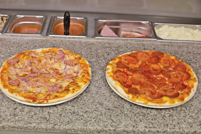Pizza Iohannis are cârnaţi, bacon, varză murată şi ceapă. Pizza Ponta: salam picant, roşii, ardei capia, sos picant