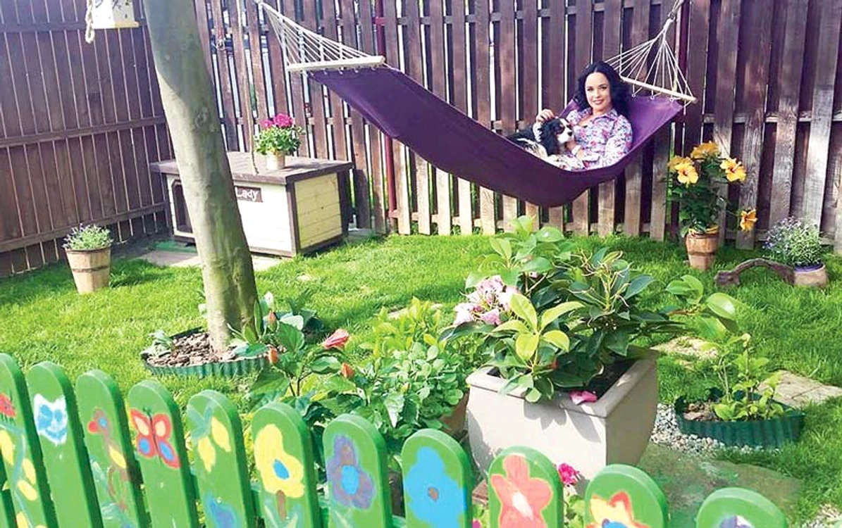
    Andreea se răsfaţă în hamac,  după câteva ore de muncă,  cot la cot cu Tuncay,  în grădina lor  