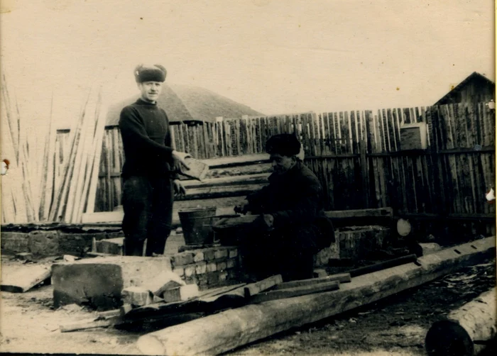 Andrei Negru,din comuna Paiu, raionul Cahul, ajutat de fiul său, Nicu, îşi construieşte o nouăcasă la marginea oraşului  Omsk ,unde a fost deportat în anul 1949 cu familia, 1957. Sursa foto Patrimoniul Muzeului Naţional deArheologie şi Istorie a Moldovei 