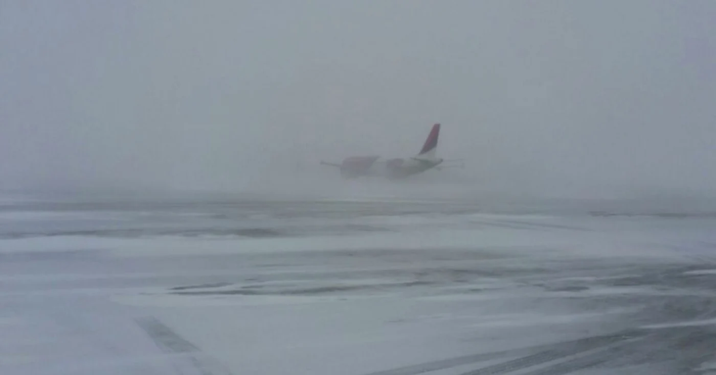 Avion blocat de zăpadă și viscol pe o pistă