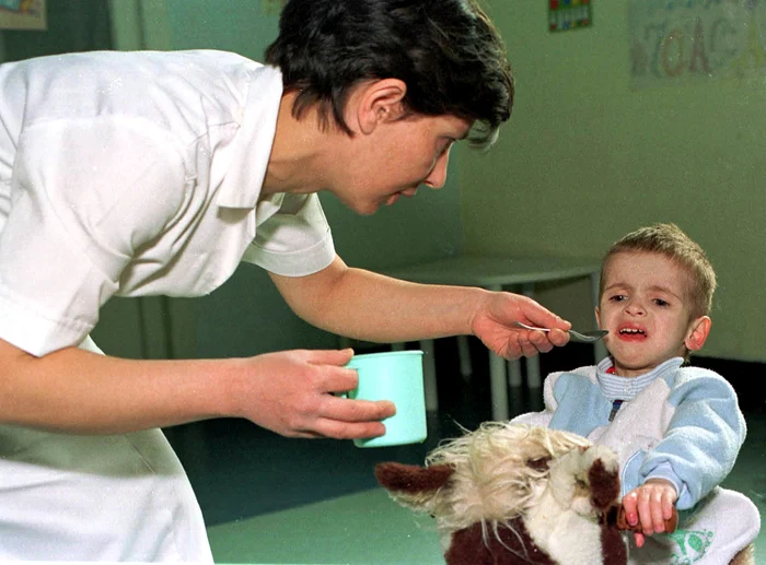 o asistenta îi da sa manance cu ligurita unui copil mic in spital - foto mediafax - marian ilie