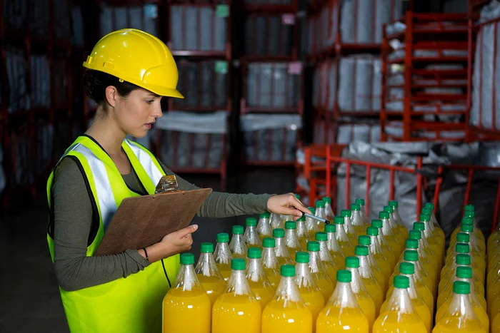female worker examining juice bottles jpg jpg