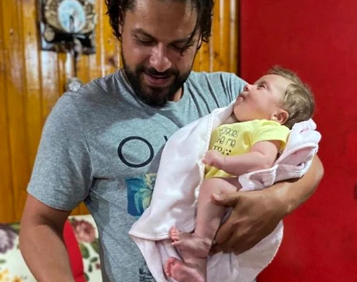 
    Augustin Viziru nu-și lasă fetița din brațe nici când taie tortul aniversarFoto: Instagram  