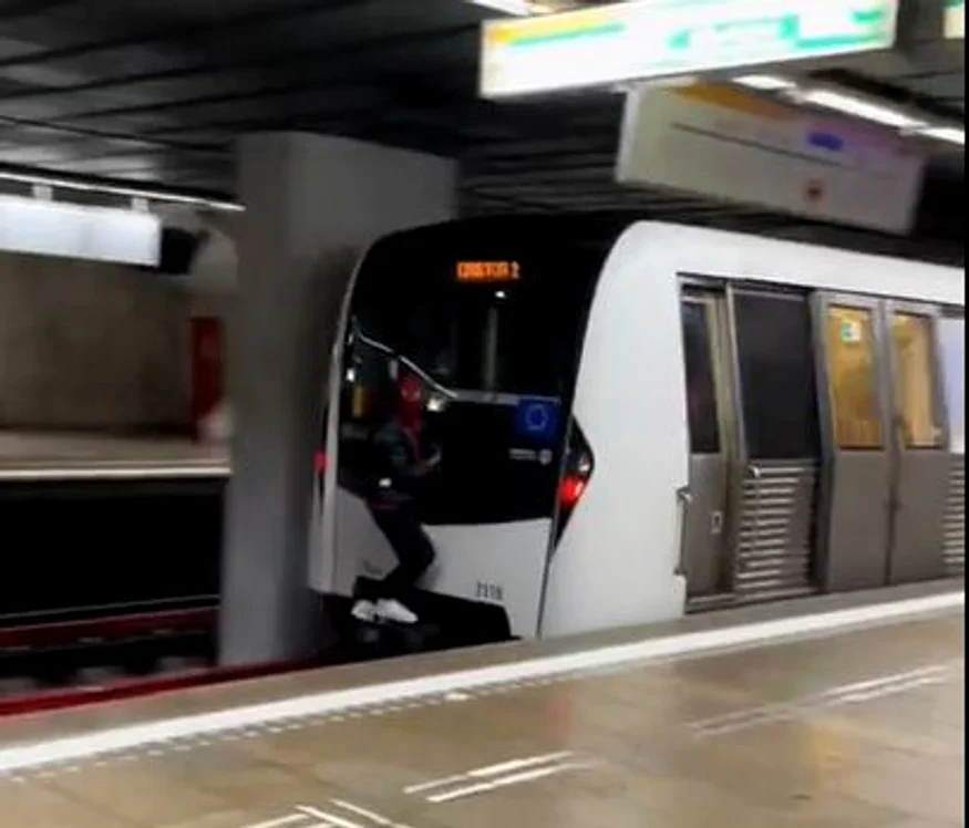 Tânărul inconștient a fost filmat cățărat pe tamponul unui tren. FOTO: Captură video