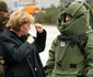 Cancelarul german Angela Merkel gesticulează în discuţia cu un soldat care poartă un costum de protecţie contra exploziilor în timpul vizitei la baza militară Letzlingen din estul Germaniei în noiembrie 2006 FOTO AP