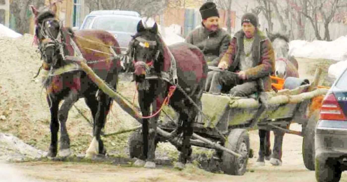 Strada Mugur. Pe partea dreaptă, a orăşenilor, trece un Mercedes, în timp ce partea stângă,  a „sătenilor“, este circulată de o căruţă 