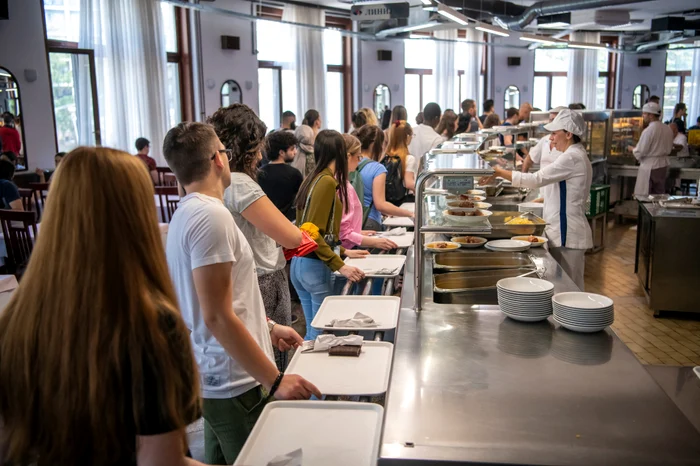 Studenți așteptând la rând la o cantină