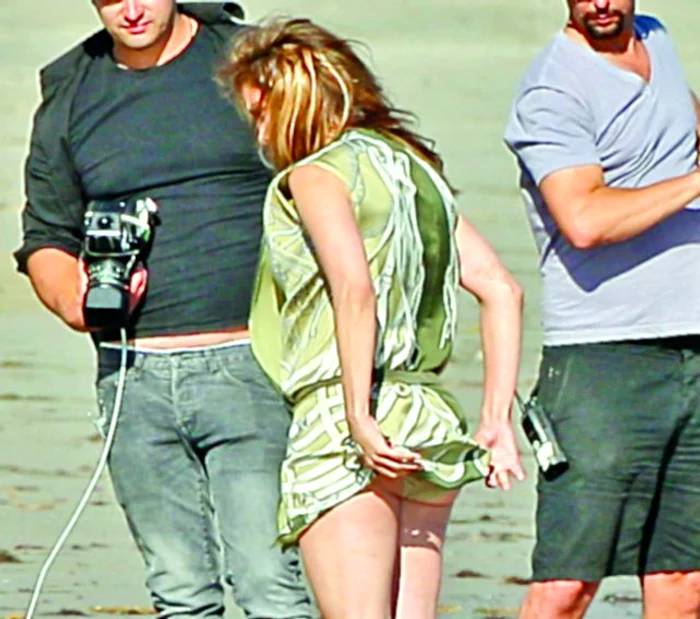 Realizând că are  fundul descoperit, vedeta   îşi trage repede rochia