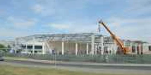 Muncitorii lucrează în paralel la demontarea fostei hale şi la construcţia noului mall