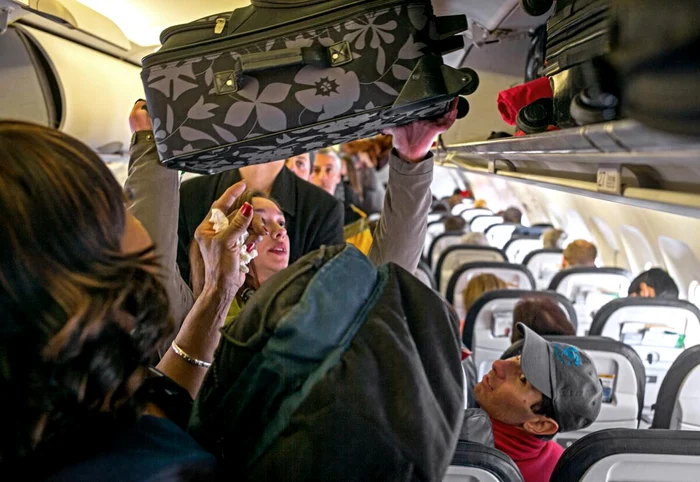 Pasagerii manevrează bagajele cât timp avionul rulează. Sursa: CA Times