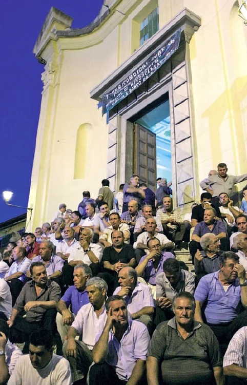 ’Ndrangheta e, la propriu, o afacere de familie – iar băieţii devin automat mafioţi. Cu aceasta în minte, să privim încă o dată acest instantaneu, care-i înfăţişează pe bărbaţii din San Luca, în faţa bisericii, la înmormântarea lui Francesco Giorgi, Sebastiano Strangio and Narco Marmo, ucişi în Germania ca parte a unei răzbunări (august 2007)