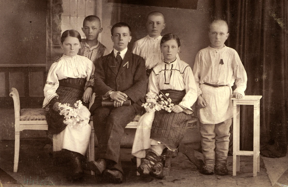 Tânărul învățător-suplinitor Gheorghe Cernea, în mijlocul elevilor săi din Platonești-Ciuc, în anul școlar 1919-1920 (© Muzeul de Etnografie Brașov)
