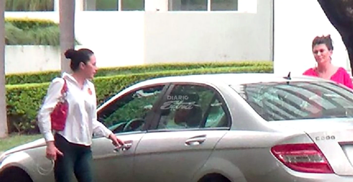 Alina Bica se urcă într-un Mercedes, împreună cu femeia în rochie roz