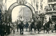 Foto sus: Trecerea familiei regale și a generalului Berthelot pe sub Arcul de Triumf ridicat pe Calea Victoriei, la intrarea în Piața Palatului Regal, la 18 Noiembrie/1 Decembrie 1918 (© Colecția Muzeului Militar Naţional „Regele Ferdinand I”)